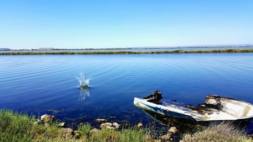 Scenic view of lake against clear blue sky