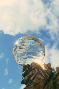 Low angle view of crystal ball against sky