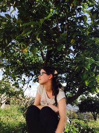 Portrait of woman against tree