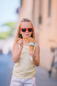 Portrait of young woman wearing sunglasses while standing outdoors