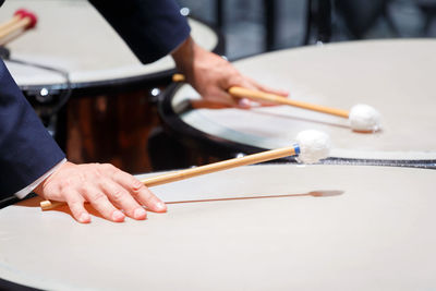 Midsection of man playing drum