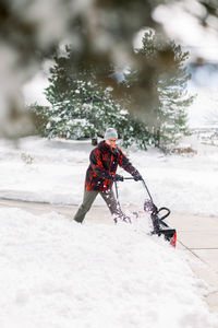 Person with umbrella on snow covered tree