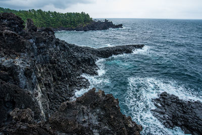 Rock formations in sea against sky