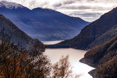 Scenic view of lake by mountains against sky