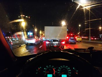 Cars on city street seen through car windshield at night