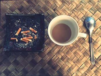 High angle view of cup and ashtray on table