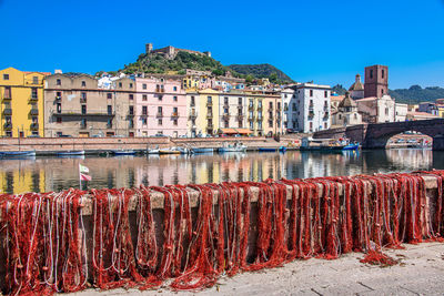 Graffiti on wooden post by river against buildings in city