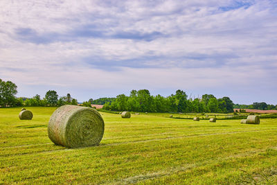 Hay bales on field against sky