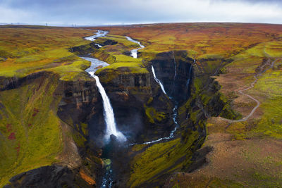 Scenic view of waterfall against sky