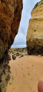 Rock formations on beach against sky