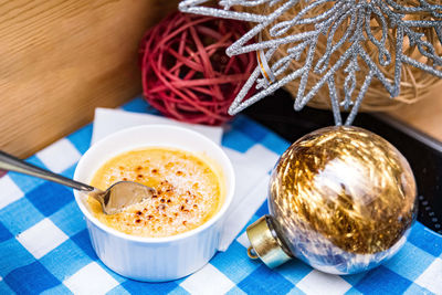 A portion of creme brulee crust on a checkered napkin and surrounded by christmas decorations