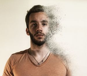 Close-up portrait of young man against white background