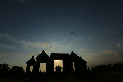 Low angle view of silhouette house against sky during sunset