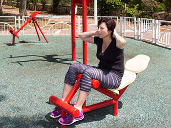 Young female athlete exercising at outdoor gym