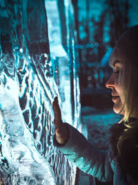 Side view portrait of young woman using mobile phone