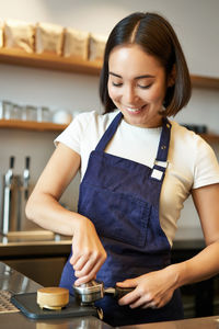 Portrait of smiling young woman standing at home