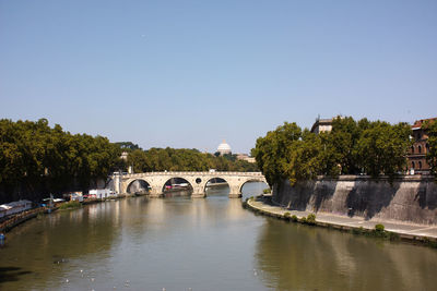 Arch bridge over tiber river against clear sky