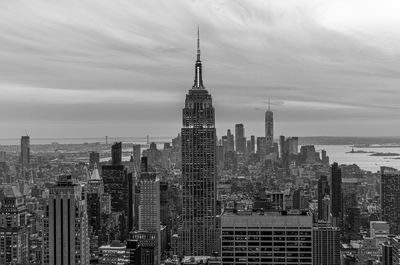 Modern buildings in city against cloudy sky