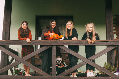 A group of children celebrating halloween on the street near the house 