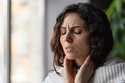 Pharyngitis. unhappy sick woman suffering touching neck, ill female having extreme throat pain