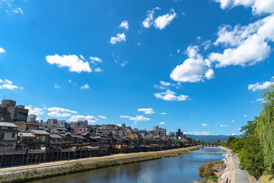 River amidst buildings in city against sky