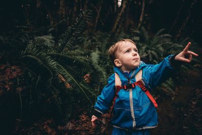 Boy standing against tree