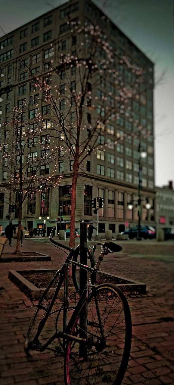 BICYCLE PARKED ON STREET BY BUILDING