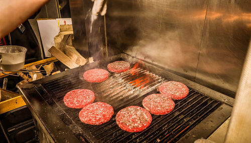 Hamuburgers cooking on grill outdoors in panoramic composition