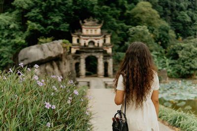 Rear view of woman standing on field