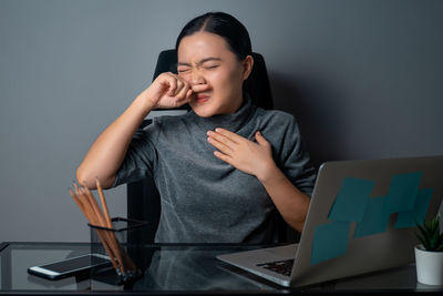 Young woman using mobile phone while sitting on table