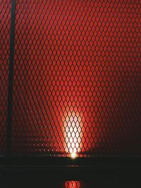 Close-up of illuminated chainlink fence during sunset