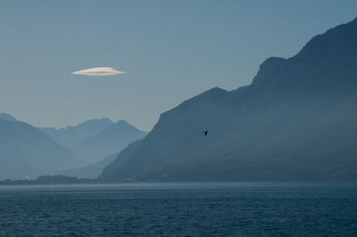 Scenic view of sea and mountains against sky