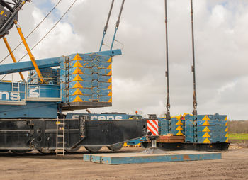 Cranes at construction site against sky