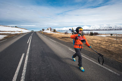 Woman running on road against sky during winter