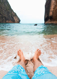 Low section of man relaxing on beach