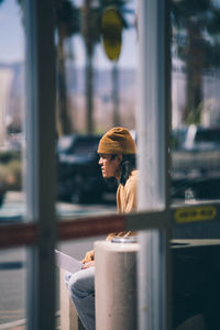 Man holding umbrella standing by window