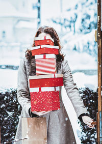 Woman standing on snow covered christmas tree