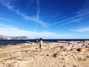 Full length of girl on beach against sky