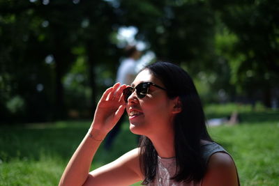 Portrait of young woman wearing sunglasses in park
