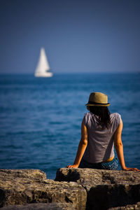 Rear view of a woman overlooking calm blue sea