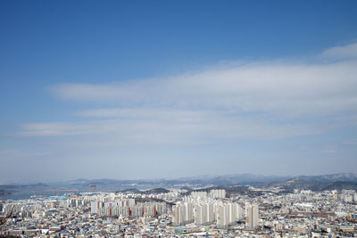 Aerial view of cityscape against blue sky