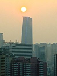 Skyscrapers in city at sunset