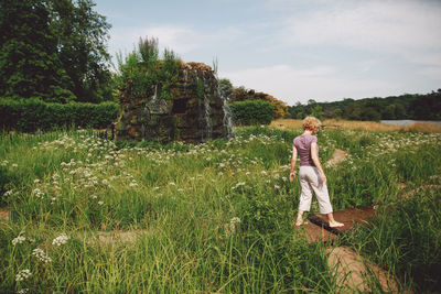 Rear view of man standing on grassy field