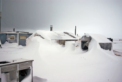 Snow covered houses against sky