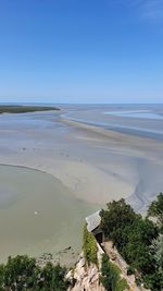 Scenic view of beach against clear blue sky
