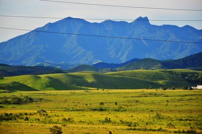 Scenic view of field and mountains against sky