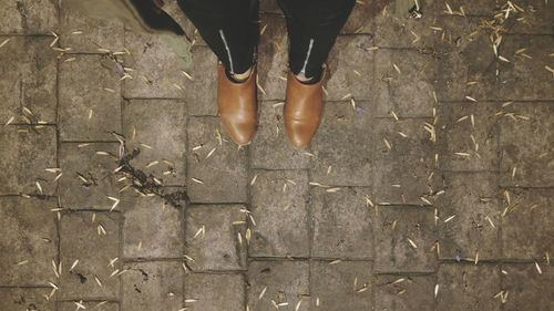 Low section of woman standing on footpath