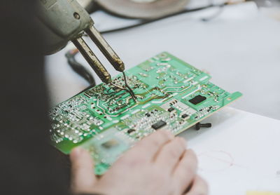 Cropped hand repairing computer chip