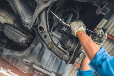 Cropped hand of man repairing car engine