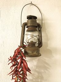 Low angle view of lantern hanging against wall